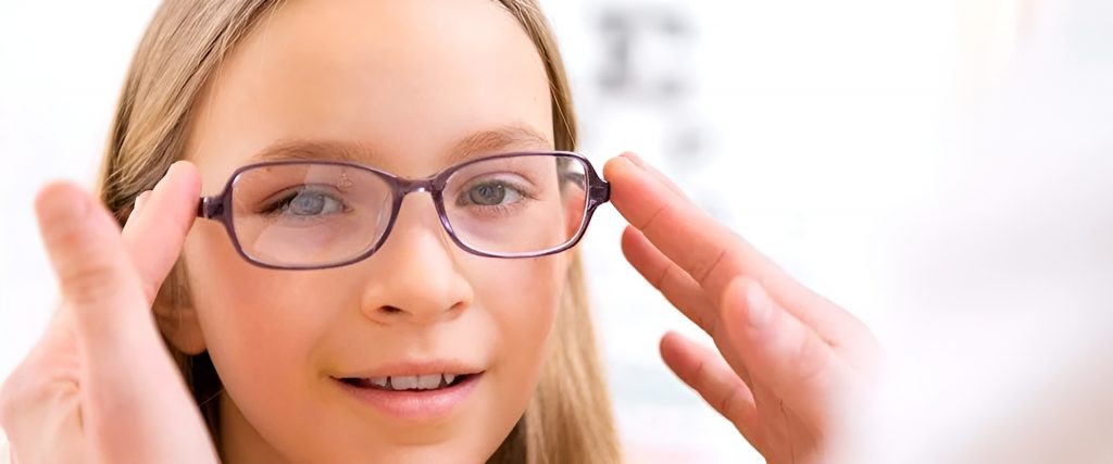 Young girl trying on eyeglasses